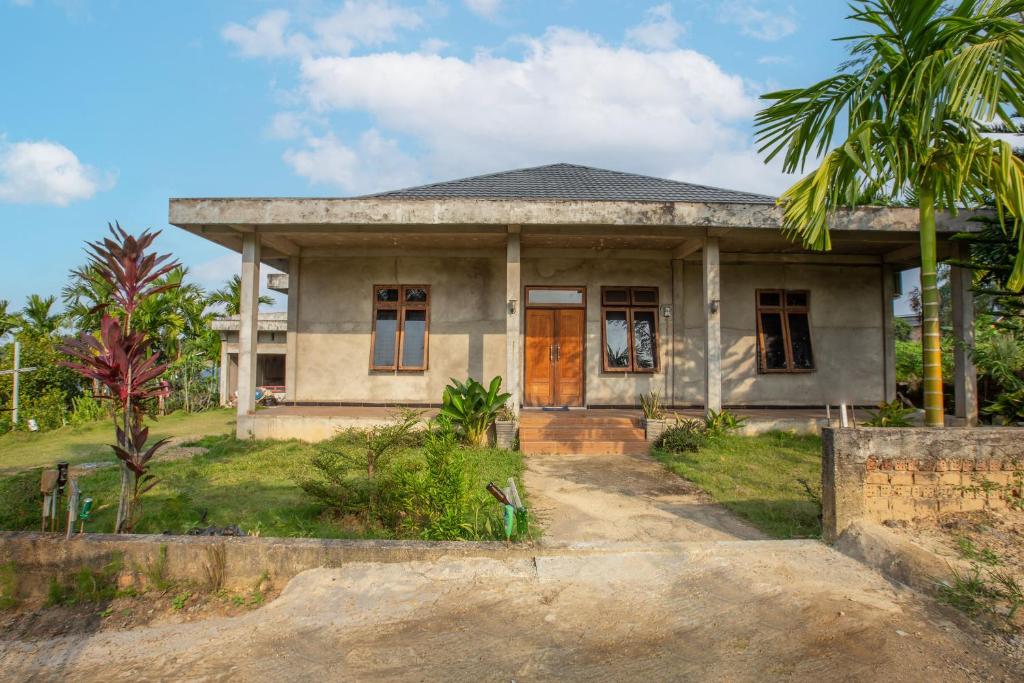 une maison sur une colline avec un palmier dans l'établissement Hotel O Homestay Romauli Kampung Radja, à Jambi