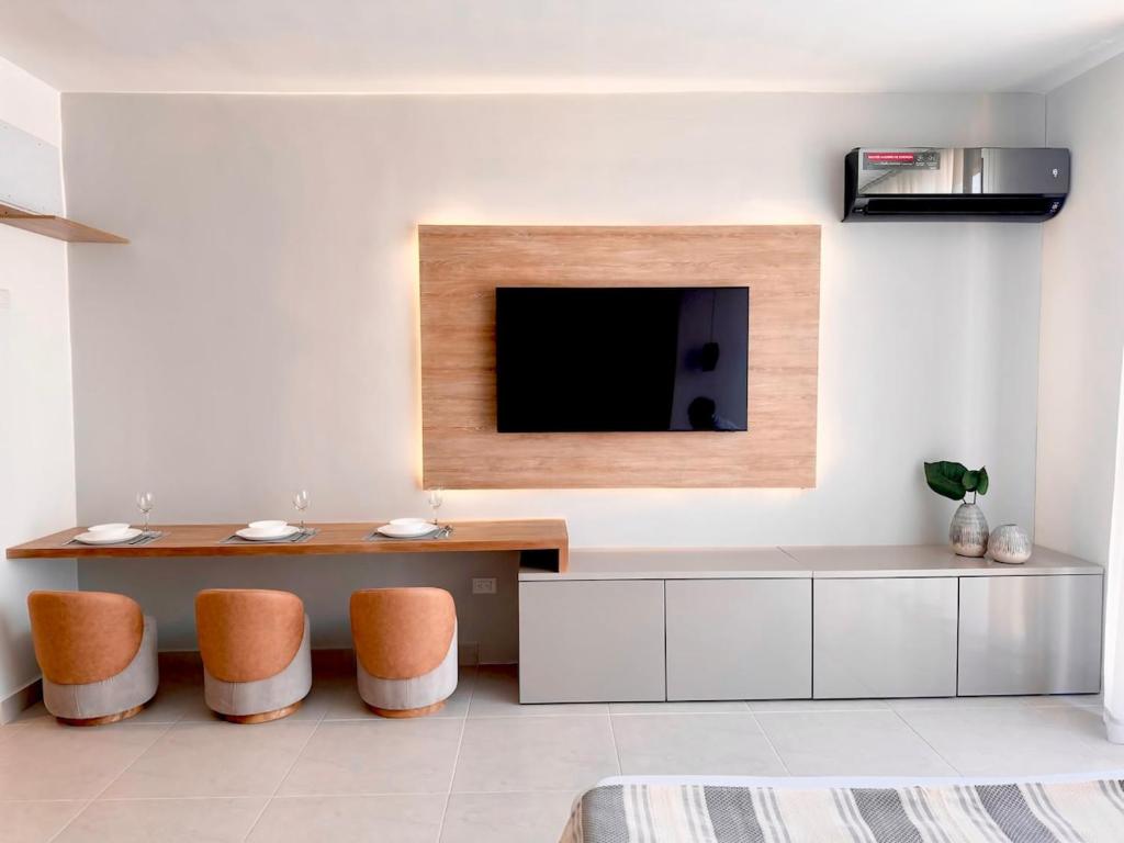 a living room with a table and a tv at Apartamento Frente al Mar D Lujo 901- Santa Marta in Playa Bello Horizonte