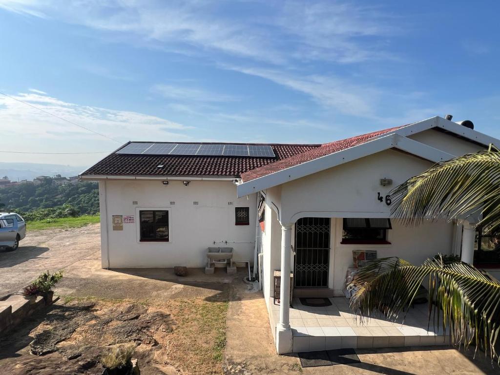 a white house with solar panels on the roof at Peace & Homely Residence in Durban