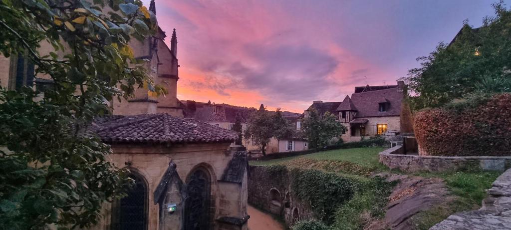 - un vieux bâtiment dans une ville au coucher du soleil dans l'établissement La perle medievale, à Sarlat-la-Canéda