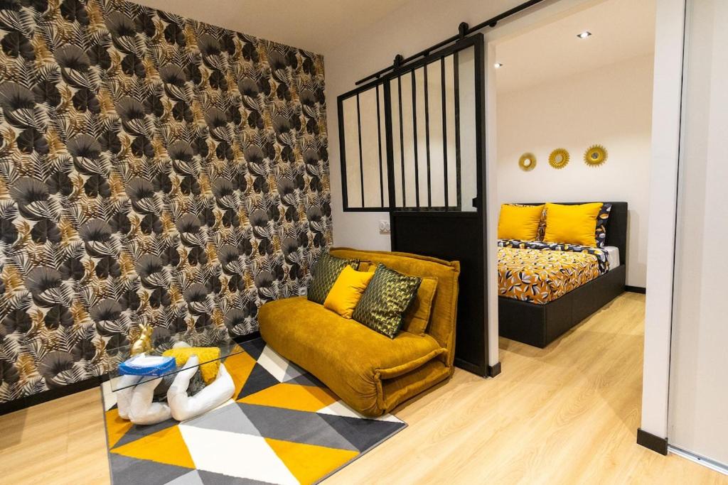 una sala de estar con un sofá y una cama en L'Éden - Centre Mulhouse - Proche Gare, en Mulhouse