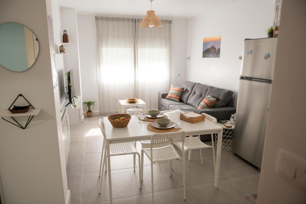 a kitchen and living room with a table and a refrigerator at O Tranvía - Apartamento en el centro de Finisterre in Finisterre