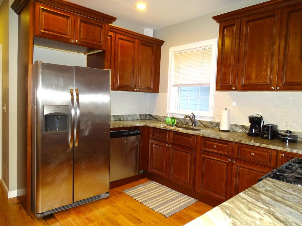 a kitchen with wooden cabinets and a stainless steel refrigerator at Beautiful 2 Bed Apt Minutes from Encore in Everett