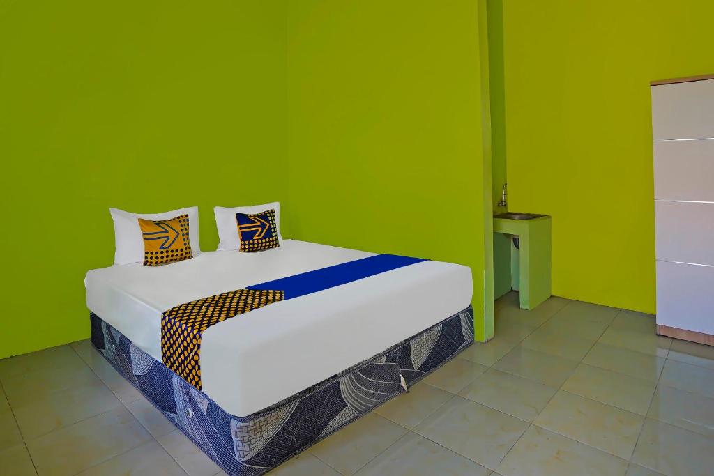 Postel nebo postele na pokoji v ubytování SPOT ON 92669 Guesthouse Prima SyariahNearGPdI Anugerah