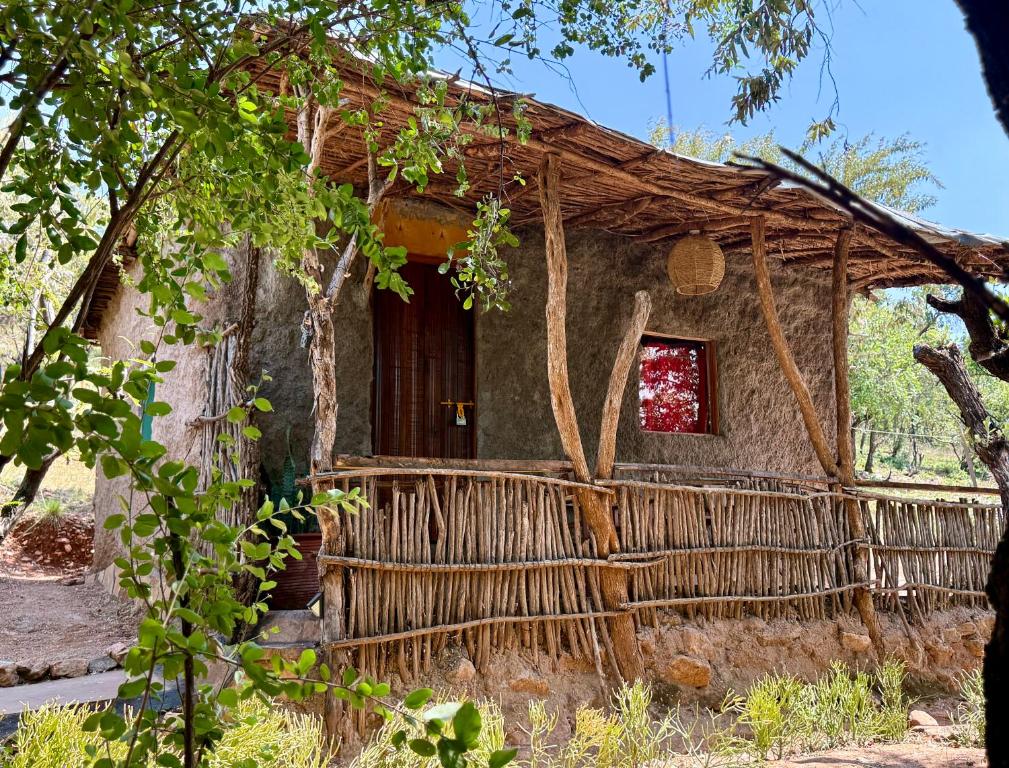 an old house with a thatch roof at 2 Authentic Mara Bush Cottages in Sekenani