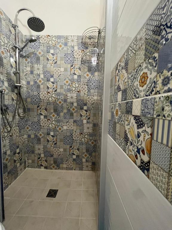 łazienka z prysznicem i mozaiką na ścianie w obiekcie B&B Regina Rooms w mieście Avola
