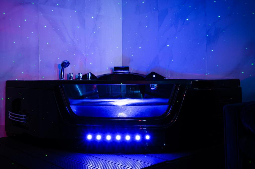a blue bath tub with lights in a room at Romantica SPA Kraków in Kraków