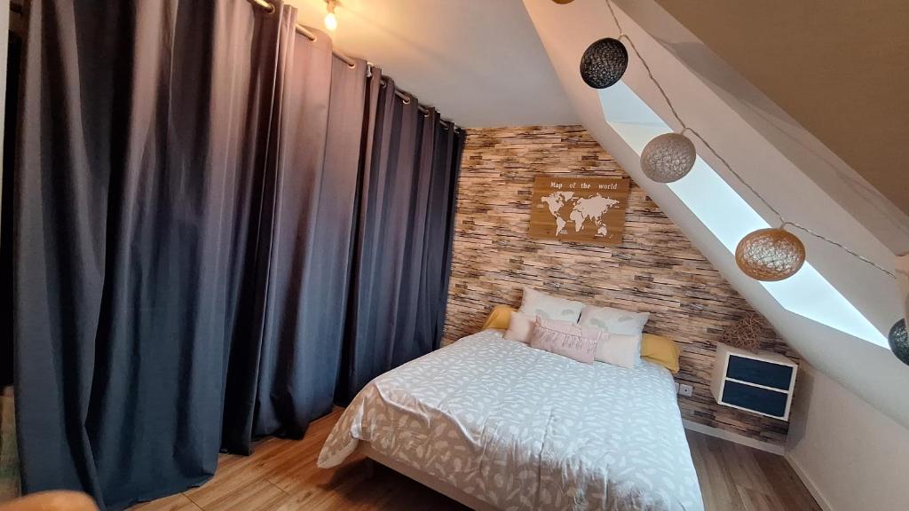 una camera da letto con un letto e un muro di mattoni di Chambre près du circuit des 24h a Cérans-Foulletourte