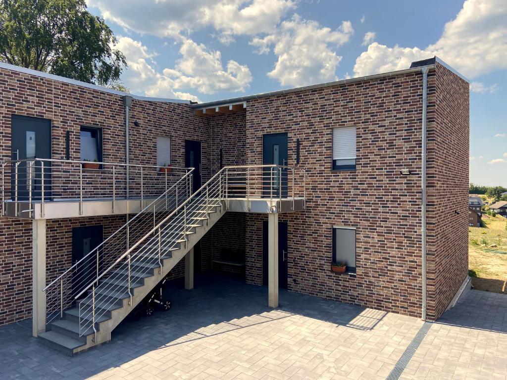 a brick building with a staircase on the side of it at Ferienwohnung Am Weiher Wohnung 7 Für 4 Personen in Nideggen