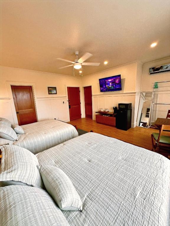 a bedroom with two beds and a ceiling fan at Hilo Town Inn in Hilo