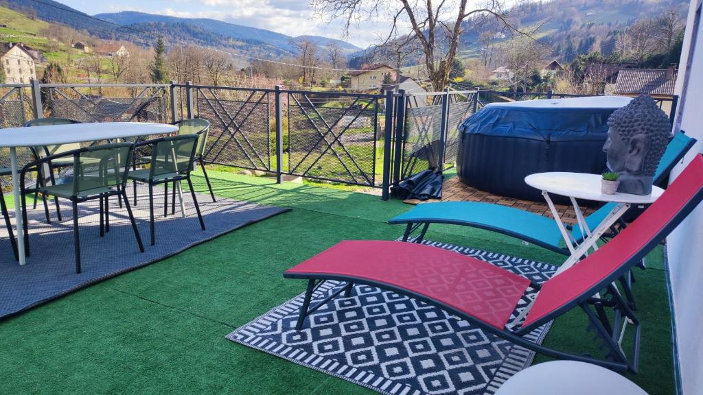 a patio with chairs and tables and a fence at Ferme perce-neige sauna et jacuzzi in Cornimont