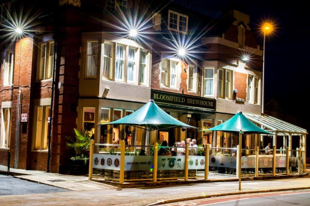 a restaurant with blue umbrellas in front of a building at Bloomfield Brewhouse in Blackpool