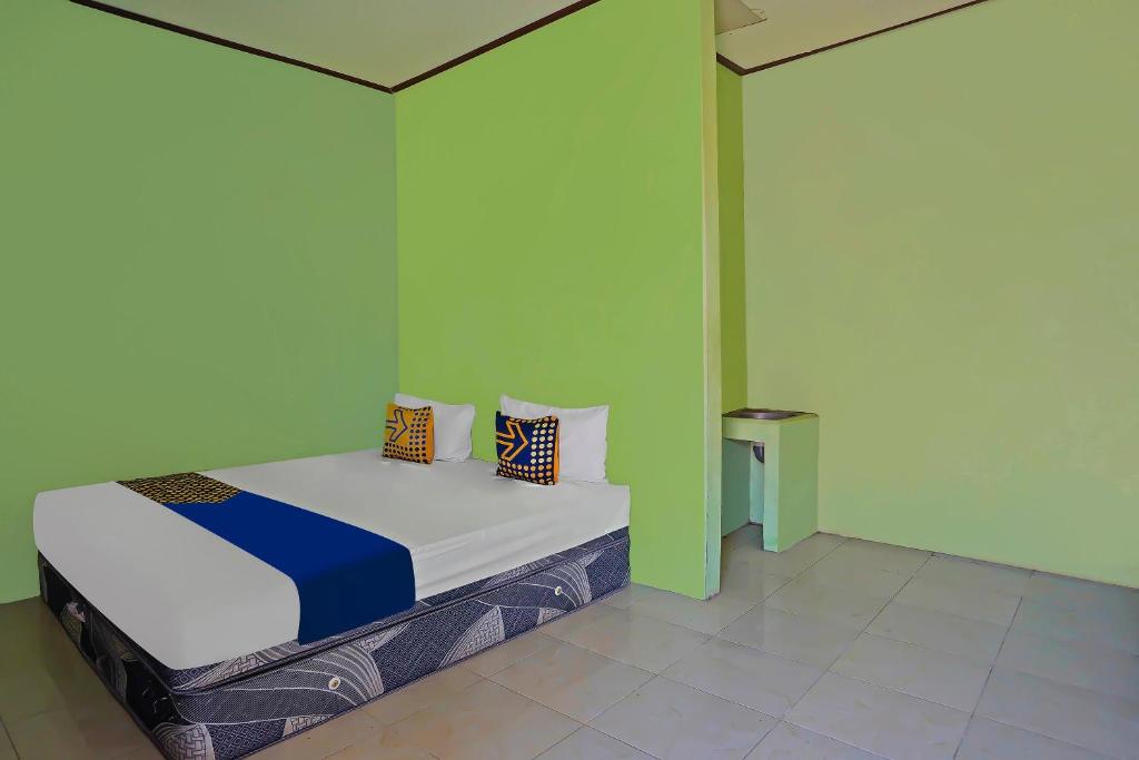 Postel nebo postele na pokoji v ubytování SPOT ON 92669 Guesthouse Prima SyariahNearGPdI Anugerah