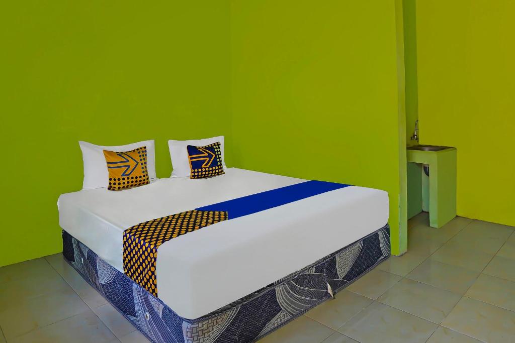 Postel nebo postele na pokoji v ubytování SPOT ON 92669 Guesthouse Prima SyariahNearGPdI Anugerah