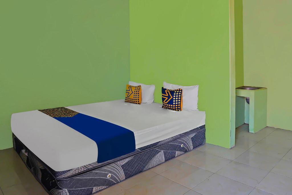 Postel nebo postele na pokoji v ubytování SPOT ON 92669 Guesthouse Prima SyariahNearGPdI Anugerah