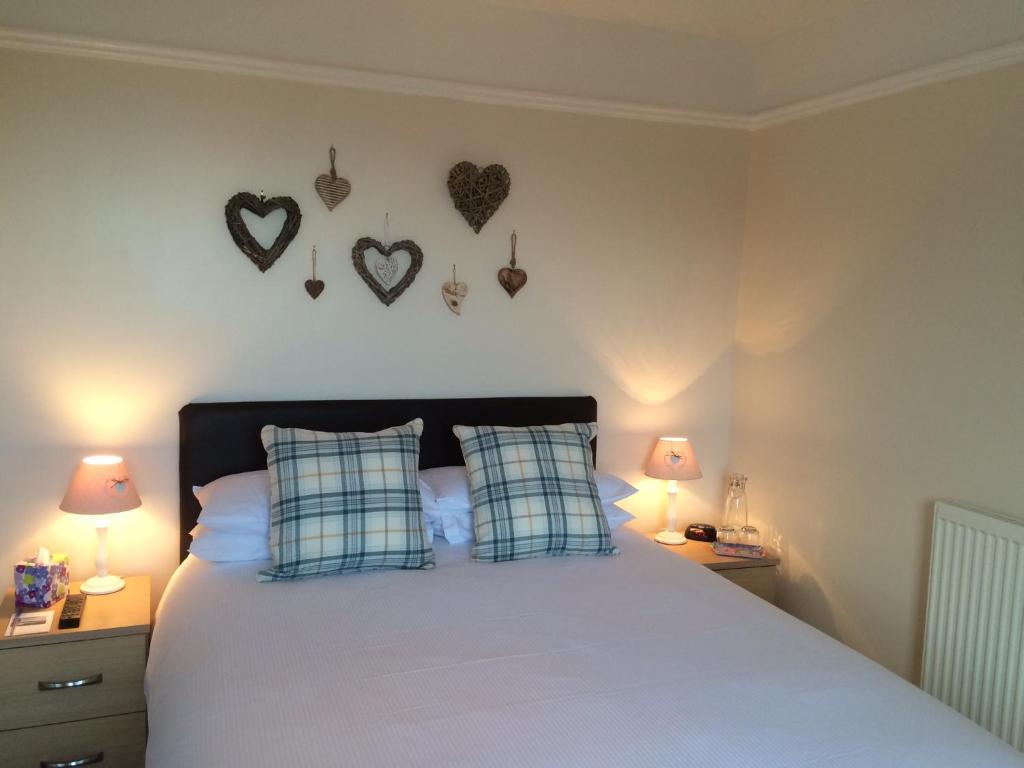 a bedroom with a bed with hearts on the wall at Nythfa Guest House in Saundersfoot