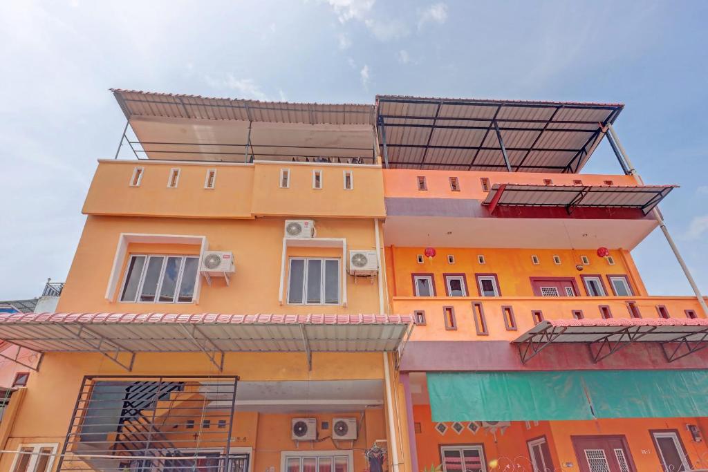 a yellow building with a solarium on top of it at Hotel O Octav Homestay in Nagoya