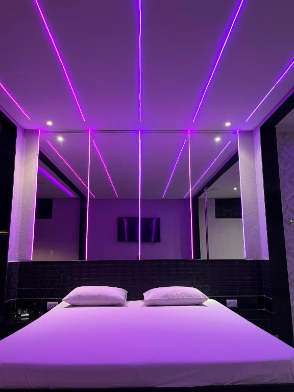 a bedroom with a bed with purple lighting at Drops Motel Goiânia in Goiânia