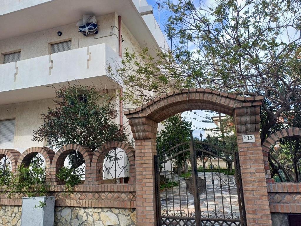 Un arco delante de un edificio con una valla. en "Bon Repòs" casa vacanza Strongoli Marina, en Marina di Strongoli