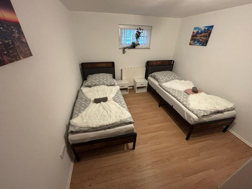 two twin beds in a room with wooden floors at Gemütliches Messe Zimmer 2-Bett in Ronnenberg