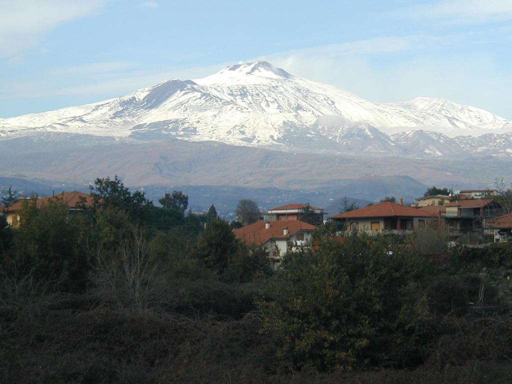 a snow covered mountain in front of a city at La casa di Elena a San Gregorio di Catania in San Gregorio di Catania