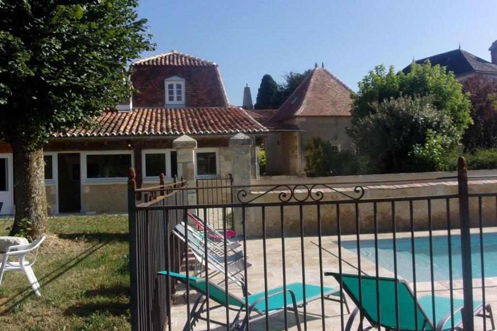 une maison avec une piscine entourée de chaises longues dans l'établissement Le Four et l'Alambic Gîtes, à Pillac