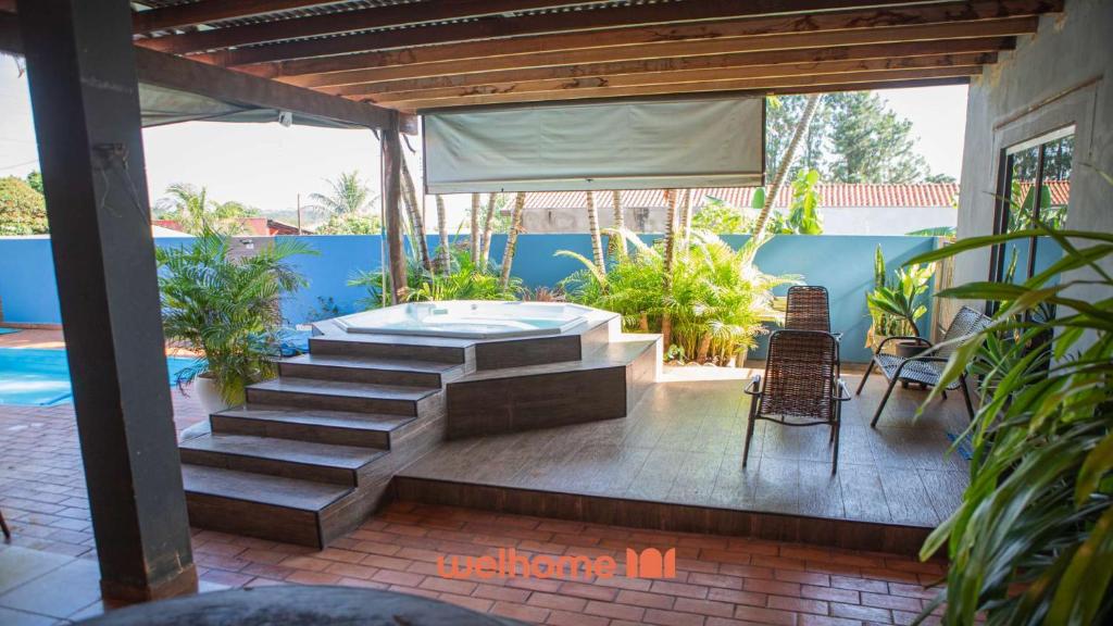 a patio with a hot tub and a table and chairs at Casa com Piscina e Lazer Completo em Barra Bonita in Igarassú
