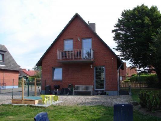 a red brick house with a porch and a balcony at Ferienhaus In Winnemark Mit Großem Garten in Winnemark
