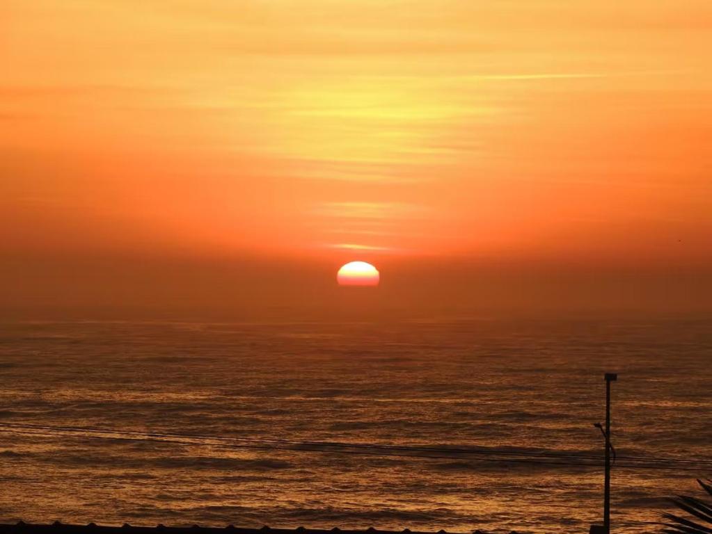 a sunset over the ocean with the sun in the sky at Ap Vista Mar 16 Minutos Beto Carrero Home Office in Piçarras