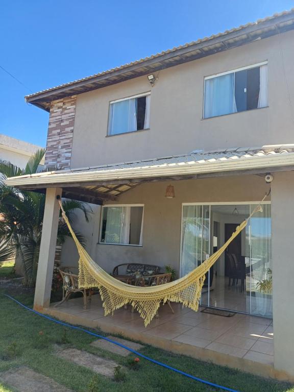 une maison avec un hamac sur un patio dans l'établissement Casa de Praia com piscina - Porto de Sauipe, à Porto do Sauipe