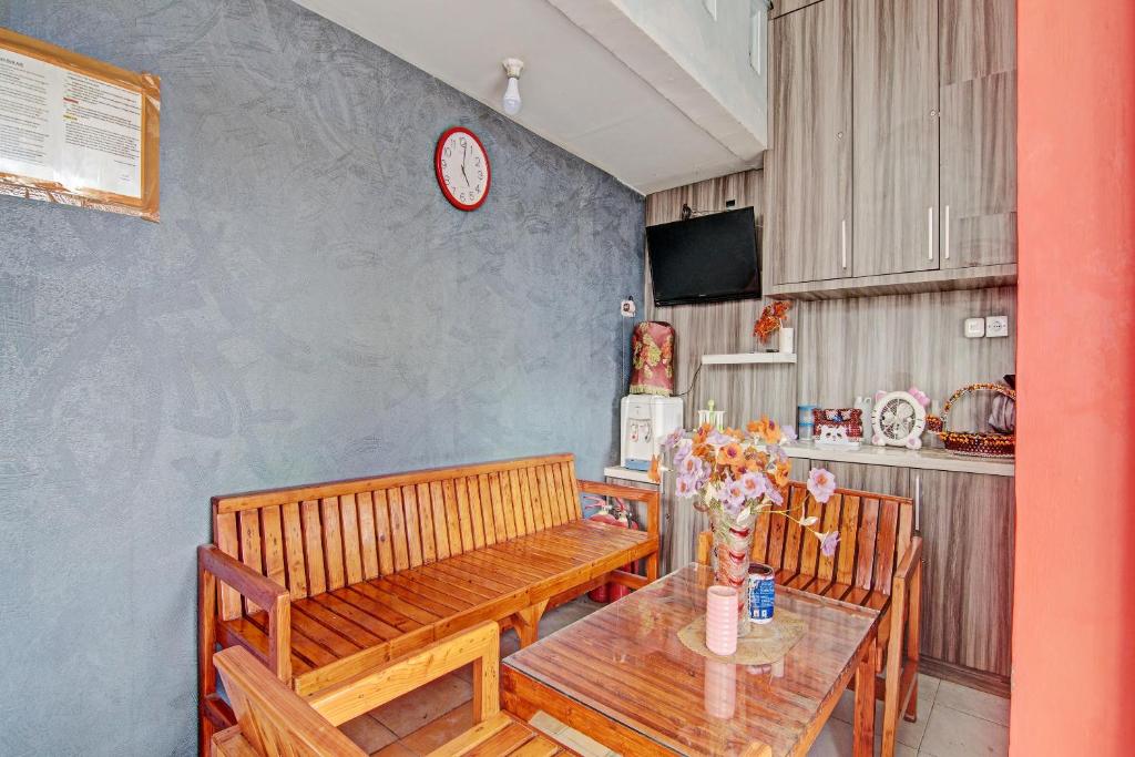 a dining room with a table and a clock on the wall at Hotel O Lestari Baru Syariah Near SMA Negeri 1 Salo in Bangkinang