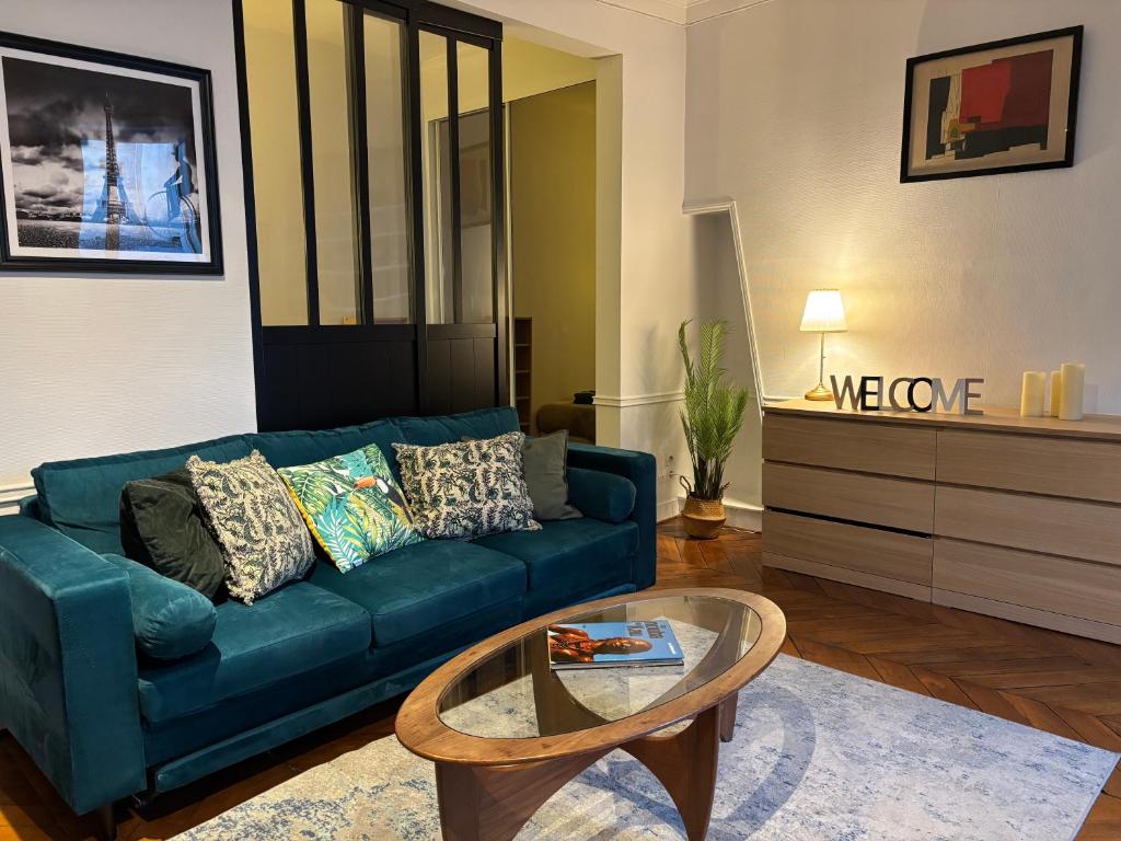 un salon avec un canapé bleu et une table basse dans l'établissement Charming Parisian loft near Opera - TF24, à Paris