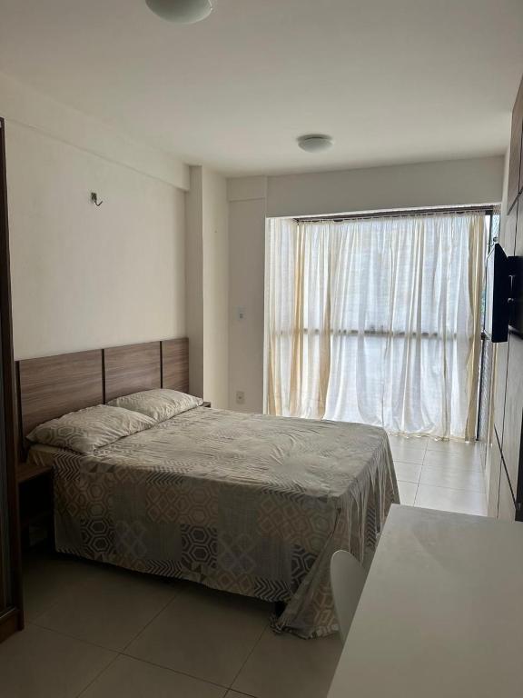 ein Schlafzimmer mit einem Bett und einem großen Fenster in der Unterkunft Excelente AP - Próximo a Shopping, Parque do Povo, Mercado in Campina Grande