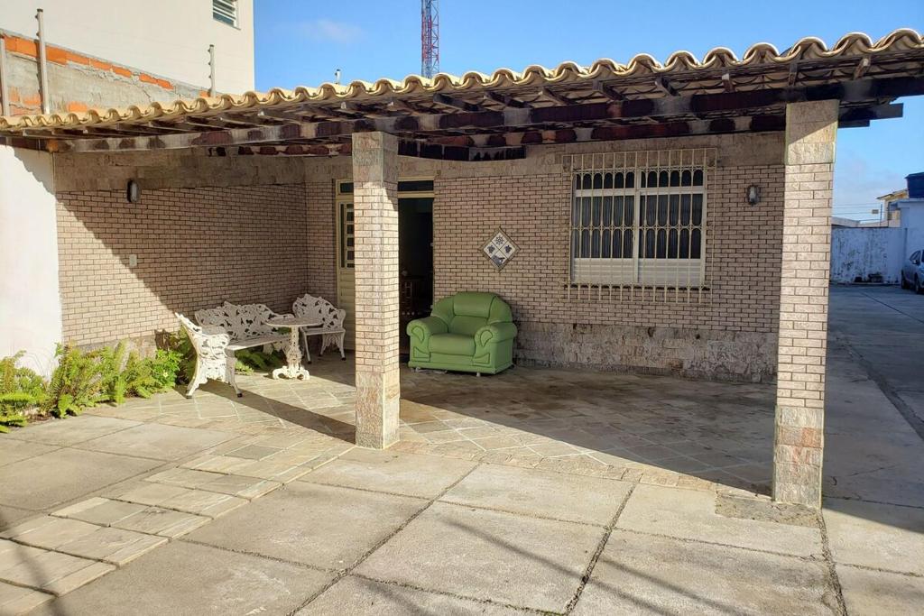 un patio in mattoni con un tavolo e una sedia verde di CASA 5 MINUTOS Da PRAIA De ARACAJU ad Aracaju