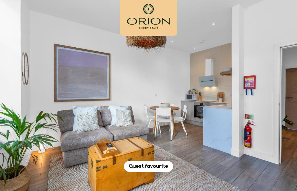 a living room with a couch and a kitchen at The Kepties 3 - Luxurious Serviced Apartment by ORION SHORT STAYS in Arbroath