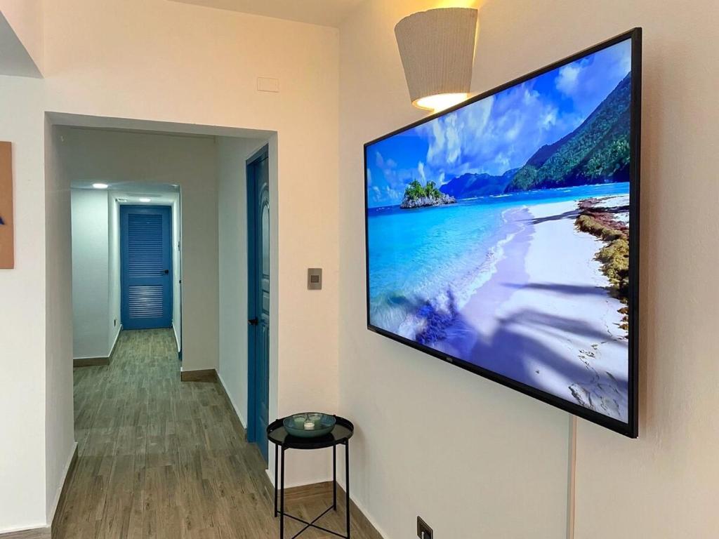 a flat screen tv hanging on a wall at Sunset View, Tanama Lodge Cap Cana, Punta Cana in Punta Cana