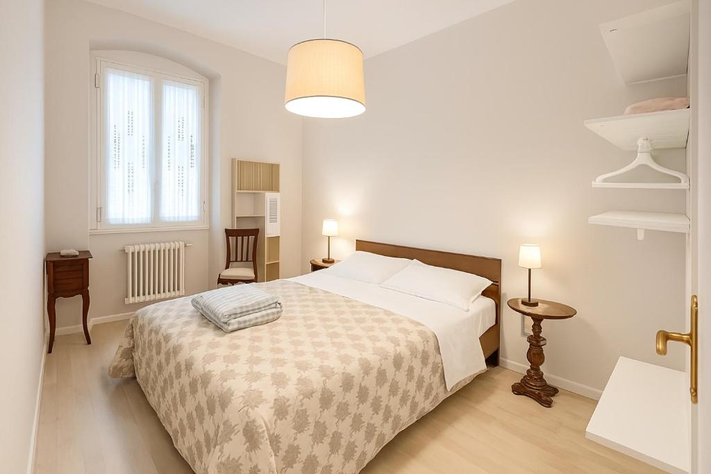 a white bedroom with a bed and a window at Chez Amèlie in La Spezia