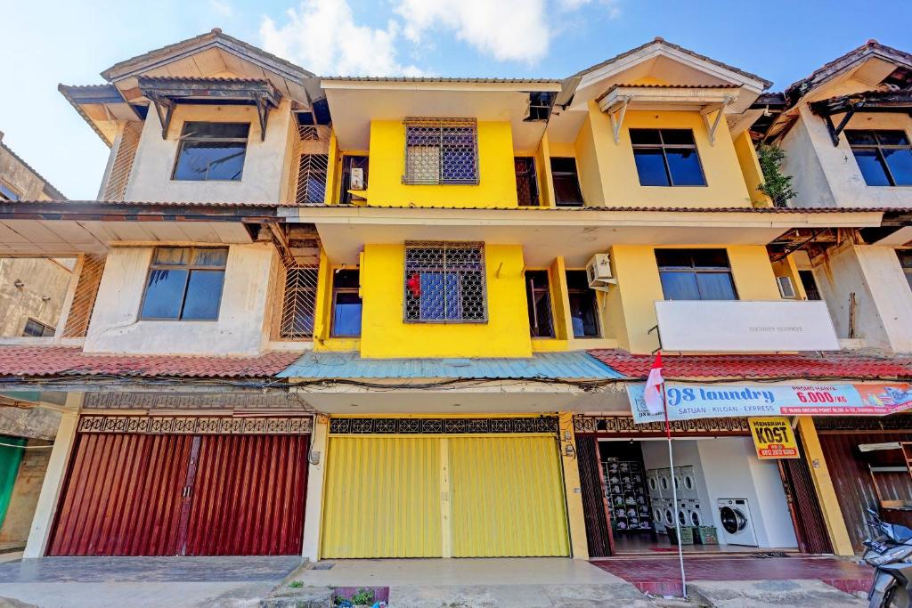 une rangée de maisons aux portes jaunes dans l'établissement Hotel O Pelita StayNearAnugrah Sinar Lautan, à Nagoya