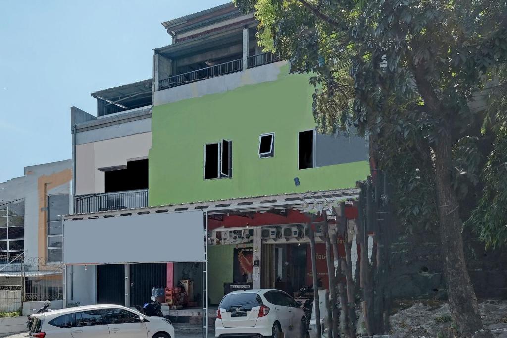 a green building with cars parked in front of it at OYO Life 92877 Hotel Rainbow 7296 in Semarang