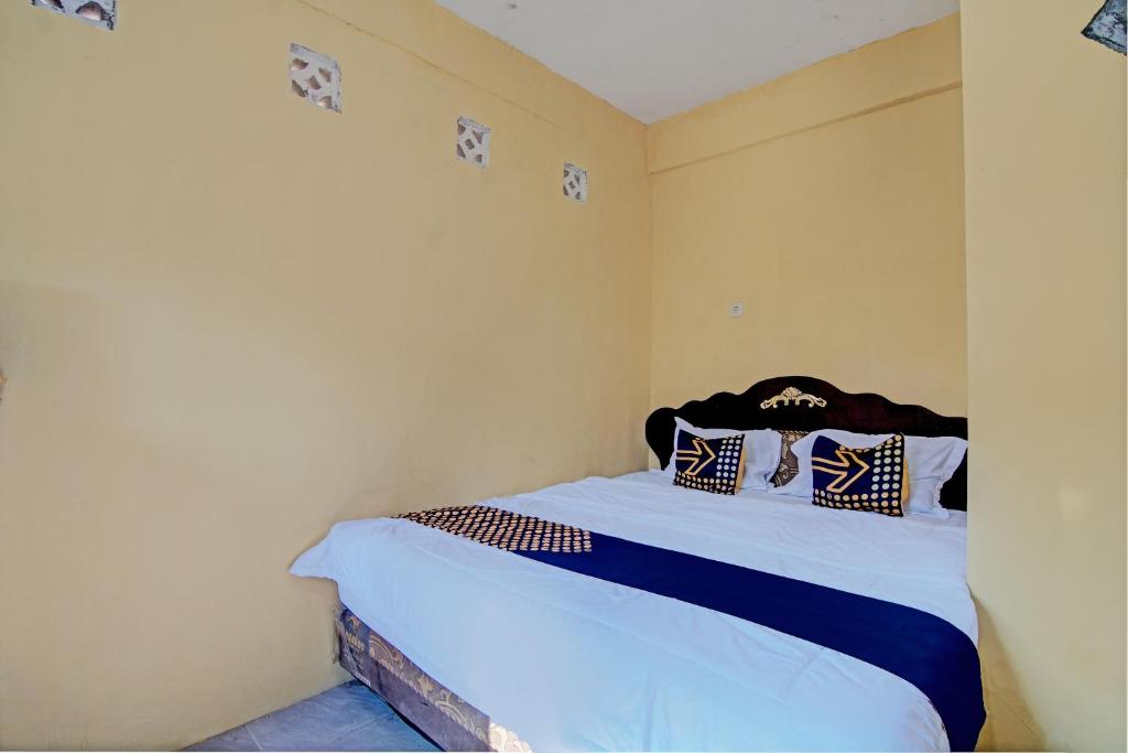 a bedroom with a bed with white sheets and pillows at Hotel O Meranti HomestayNearJembatan Siak in Pekanbaru