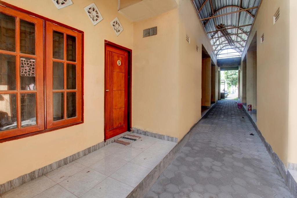 a corridor of a building with a red door at OYO Life 92846 Kost Putra Griya Eka in Tanjungkarang