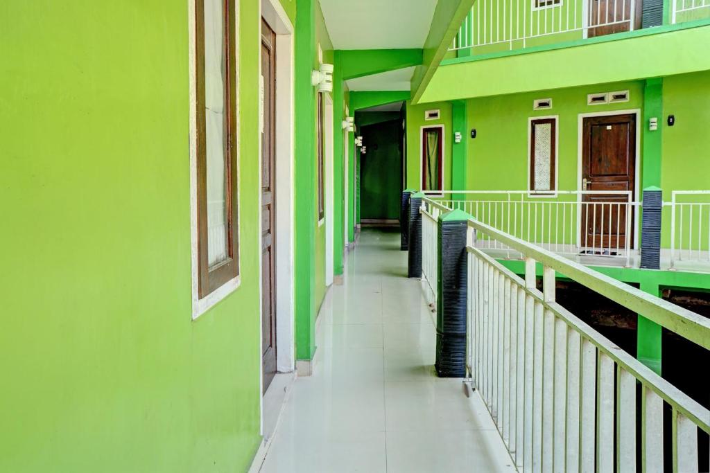 un couloir vide d'un bâtiment aux murs verts dans l'établissement OYO Life 92919 Kost Wijaya Kusuma Lake Syariah, à Madiun