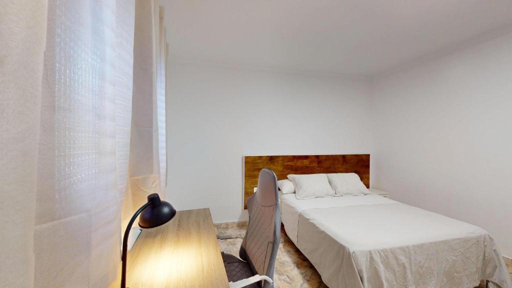 1 dormitorio con 1 cama, 1 mesa y 1 lámpara en Apartamento Relax 2, en Las Palmas de Gran Canaria