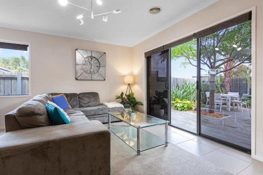 a living room with a couch and a glass table at Cosy 3-Bedroom Retreat with Outdoor Space in Torquay