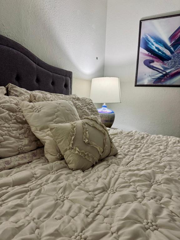 een slaapkamer met een groot wit bed en een lamp bij Cozy Room close to the strip in Las Vegas in Las Vegas