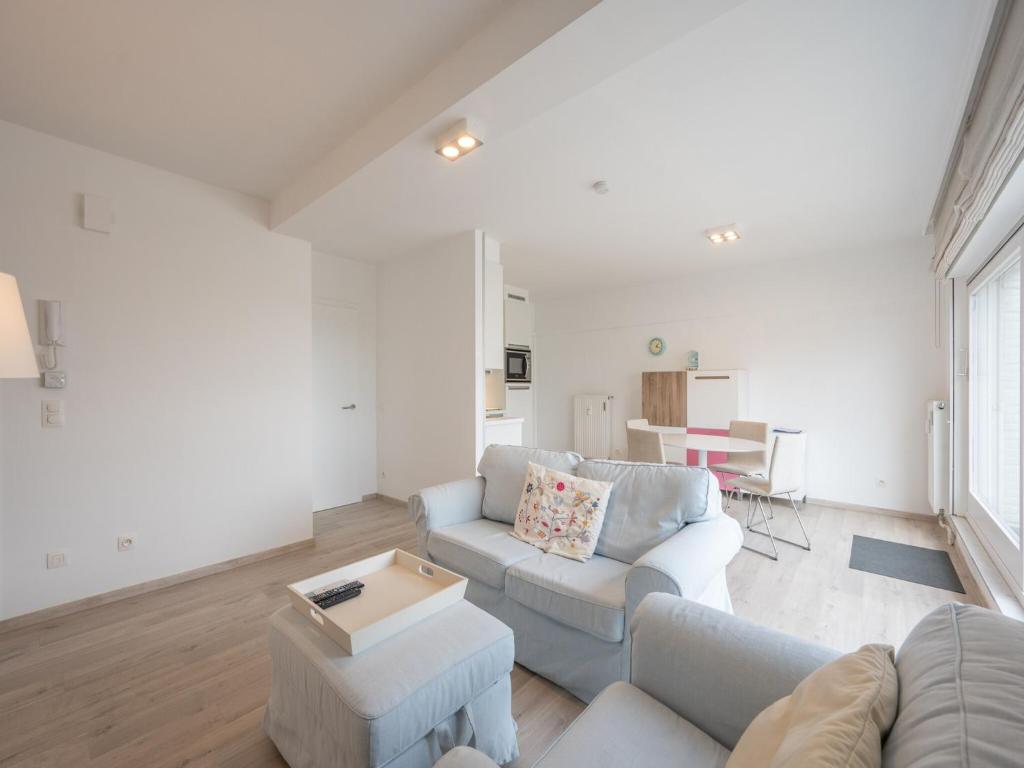 a living room with a couch and a table at Stylish City-View Retreat in Knokke-Heist