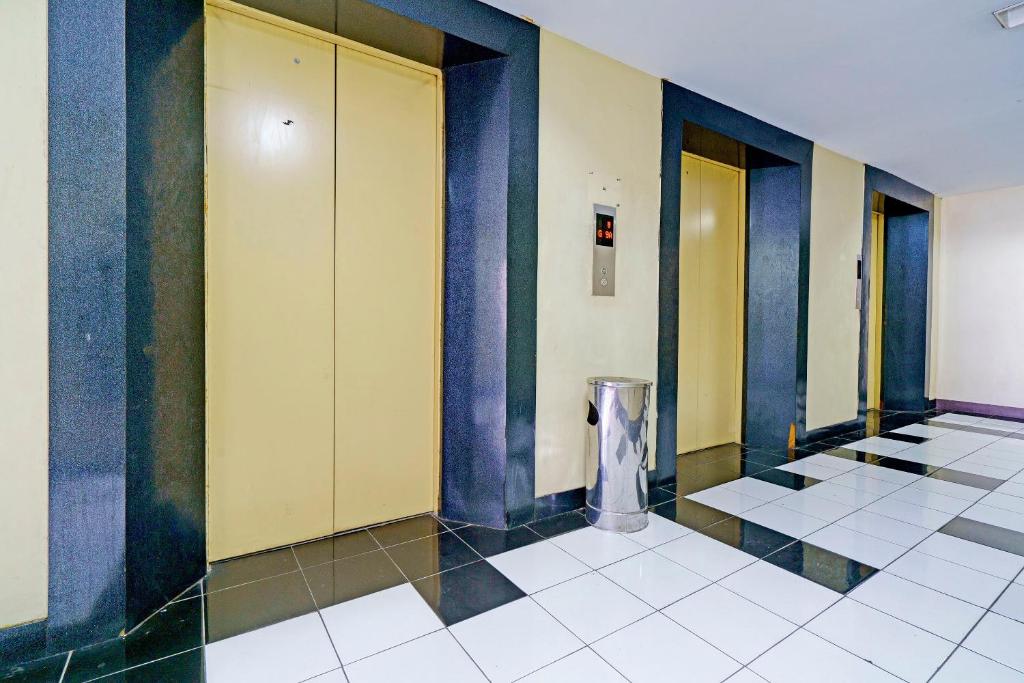 een hal met gele en blauwe muren en een vuilnisbak bij OYO Life 92949 Apartemen Gateway Cicadas By Qq Rent in Bandung