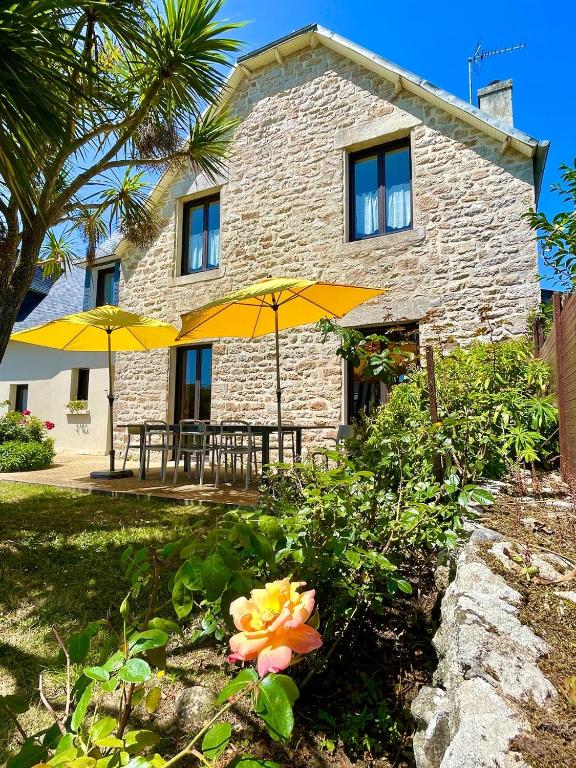 une maison avec deux parasols jaunes devant elle dans l'établissement Villa Kérity-Ki - au coeur du port typique de Kérity, à Penmarcʼh