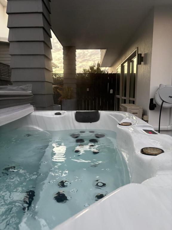a jacuzzi tub in the backyard of a house at Papamoa Family Beach House in Tauranga