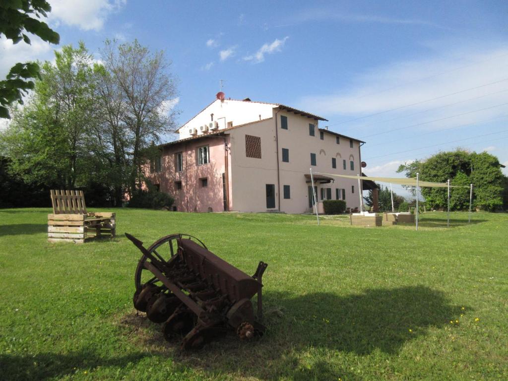 a bench in the grass in front of a building at Casal Bengodi in Poggio a Caiano